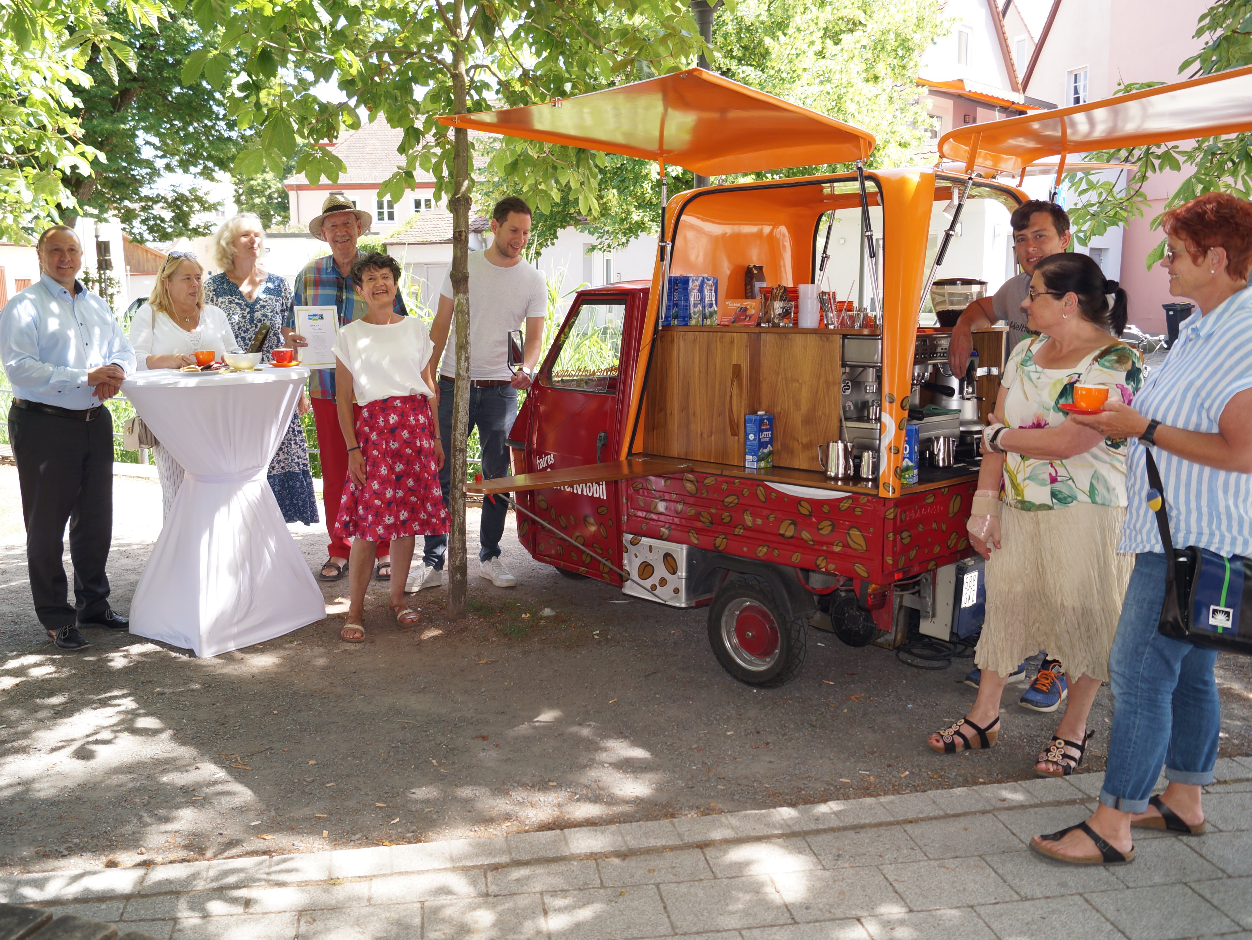 Die Fairtrade-Gruppe am Sparkassenplatz mit dem roten Cafemobil